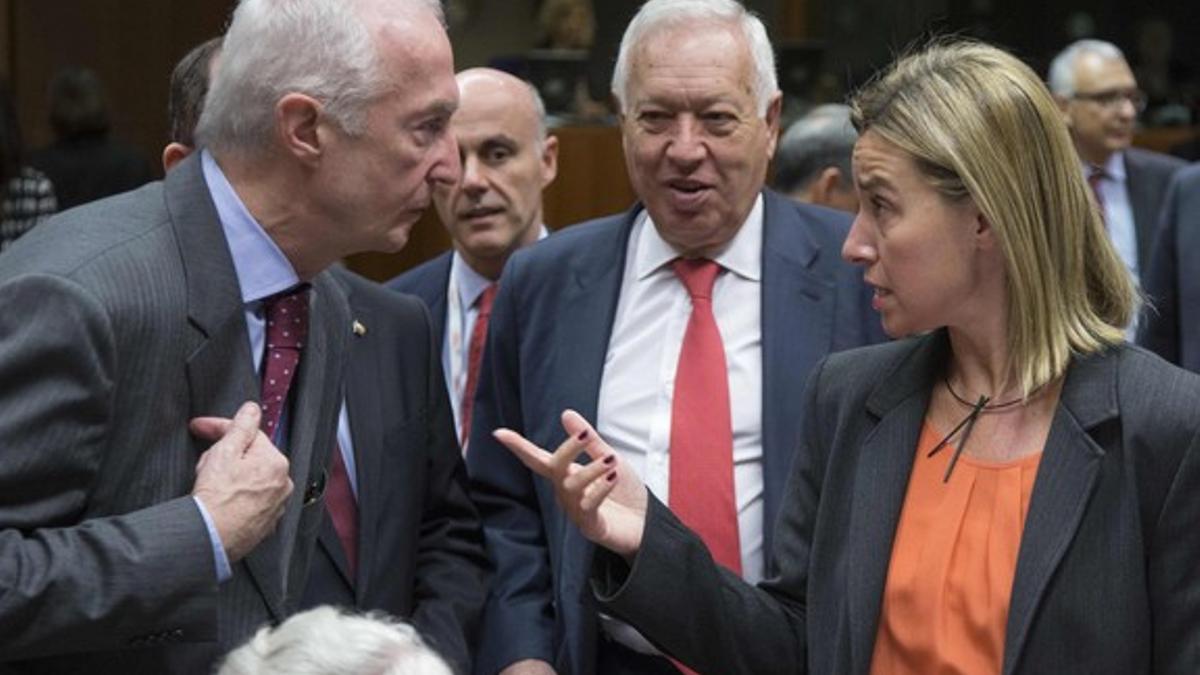 Margallo observa a la jefa de la diplomacia europea, Federica Mogherini, y al coordinador de la política antiterrorista de la UE, Gilles de Kerkhove, este lunes en Bruselas.