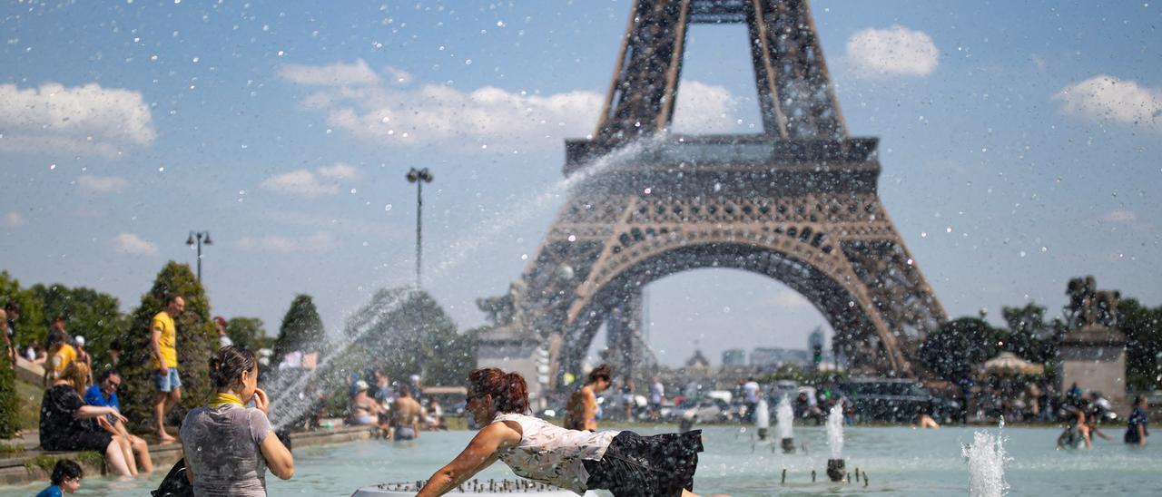 Gent refrescant-se, prop de la Torre Eiffel a París.