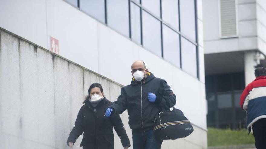 Una pareja con mascarillas en los accesos del Chuac.