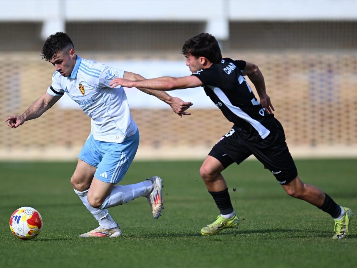Juan Carlos Sabater conduce el balón perseguido por un jugador de la UD Logroñes.