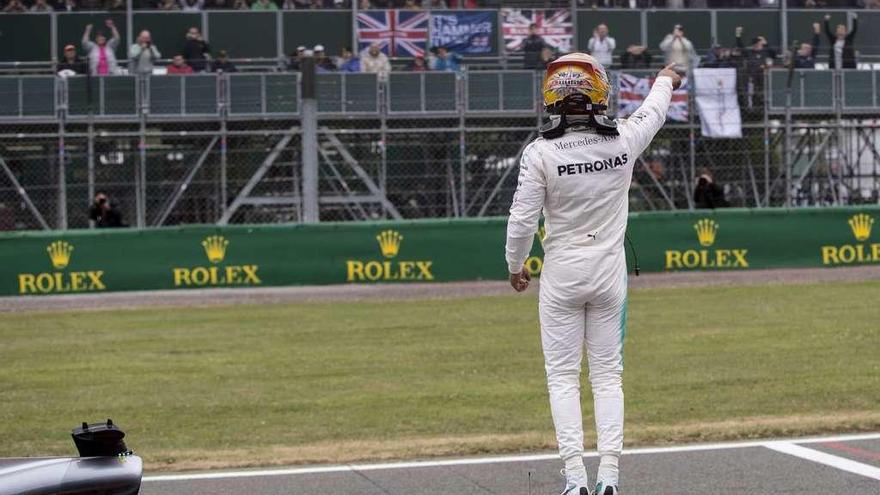 Hamilton saluda al público de Silverstone desde el morro de su monoplaza tras lograr la &quot;pole&quot;. // Valdrin Xhemaj