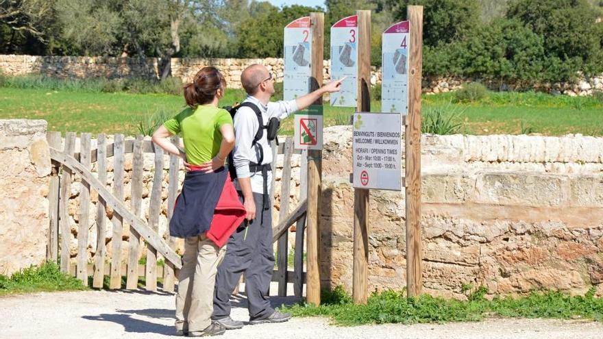 Dos turistas consultan la información sobre las rutas senderistas en la finca de Son Real.