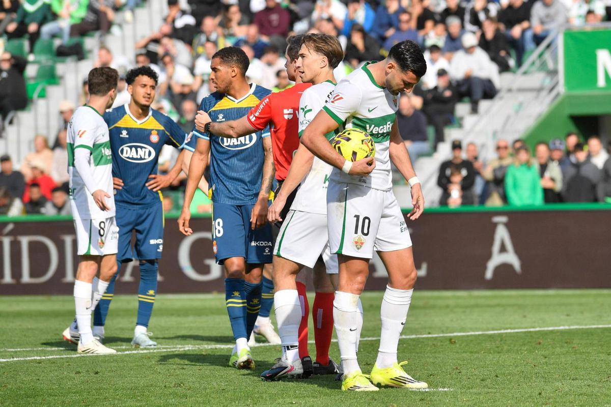 Mir se dispone a lanzar el penalti, con El Hilali recriminándole al fondo