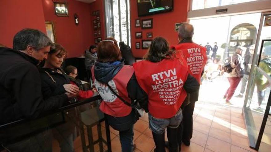 Trabajadores de RTVV siguen el debate desde un bar próximo a las Cortes.