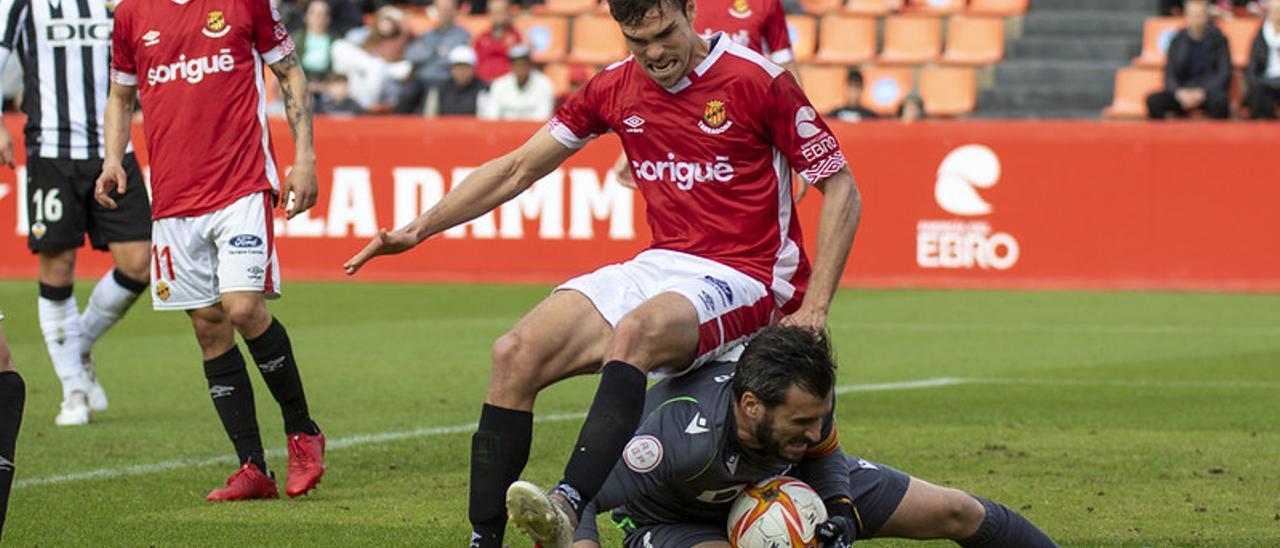 El meta Álvaro Campos detiene el balón ante la presión de un jugador del Nàstic, el pasado domingo en Tarragona.