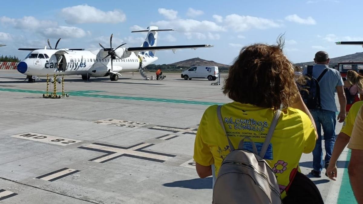Una de las pasajeras de Canaryfly, miembro de la Asociación 'Kilómetros por Sonrisas', a punto de coger un avión de la aerolínea canaria.