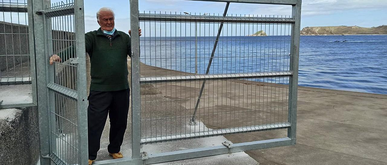 El presidente de la Asociación de Vecinos “Nuestra Señora del Carmen”, de San Esteban, Anselmo Hulton, en una de las vallas instaladas en la barra del puerto murense, con la puerta abierta. | S. Arias