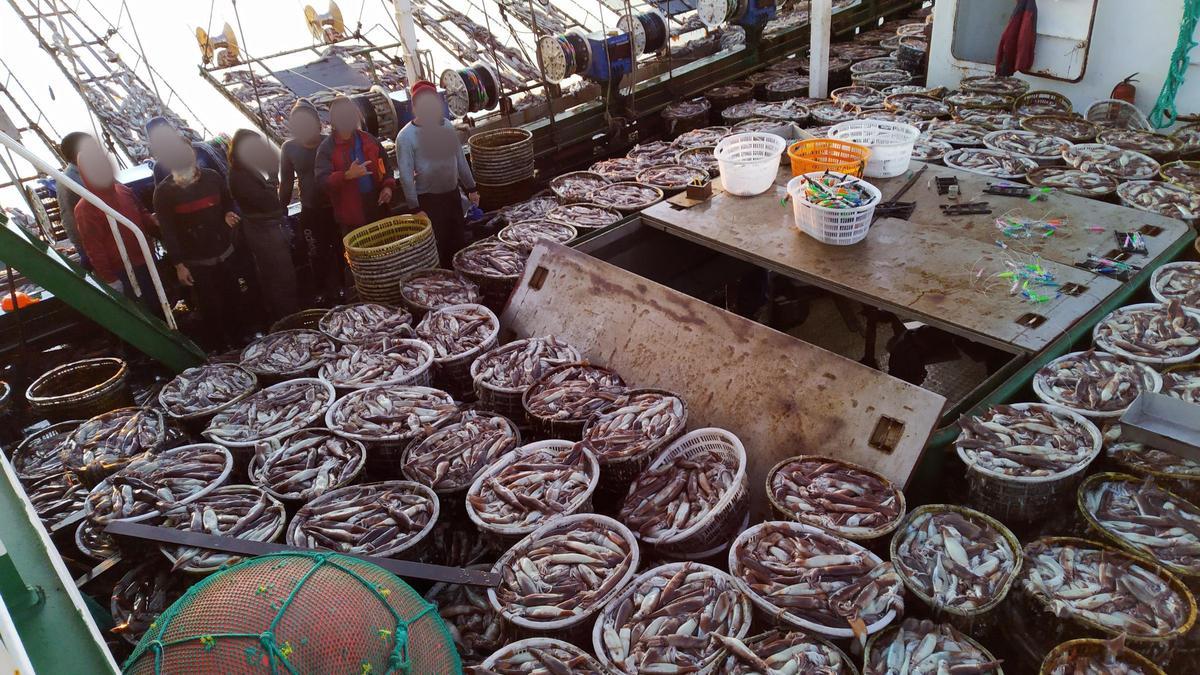 Cubierta de un potero chino hasta los topes de calamares.