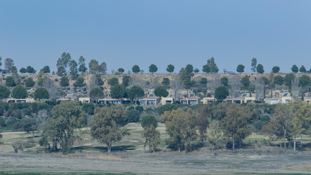 Vista de algunas de las villas del complejo Marina Isla de Valdecañas desde la orilla del embalse.