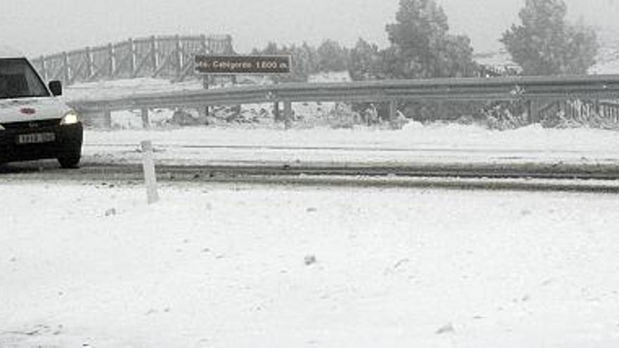 Un vehículo circula hoy por por el Puerto de Cabigordo (Teruel), de 1.600 metros, cubierto por la nieve tras la caída de las últimas horas unida a temperaturas cercanas a los cinco grados bajo cero.