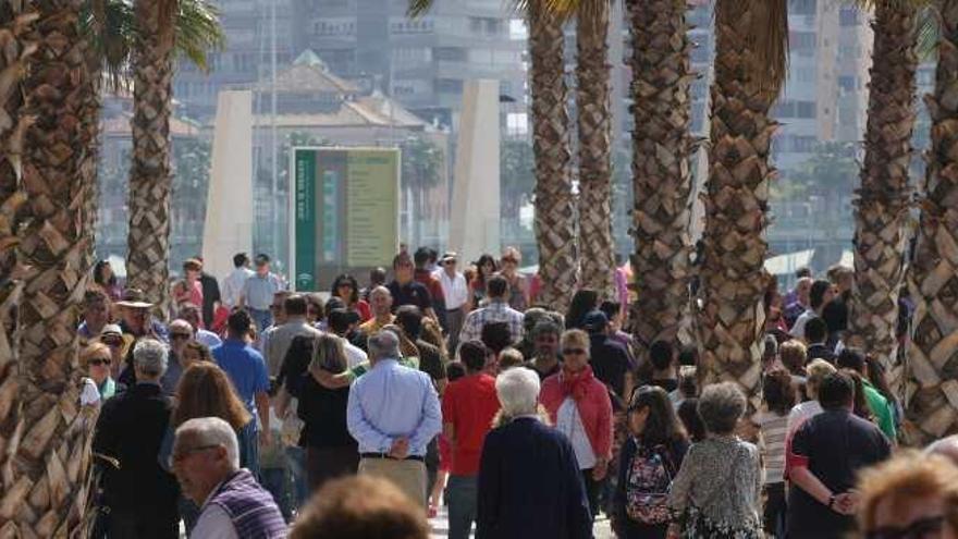 Turistas y malagueños paseando por el Palmeral de las Sorpresas, en el Puerto de Málaga.