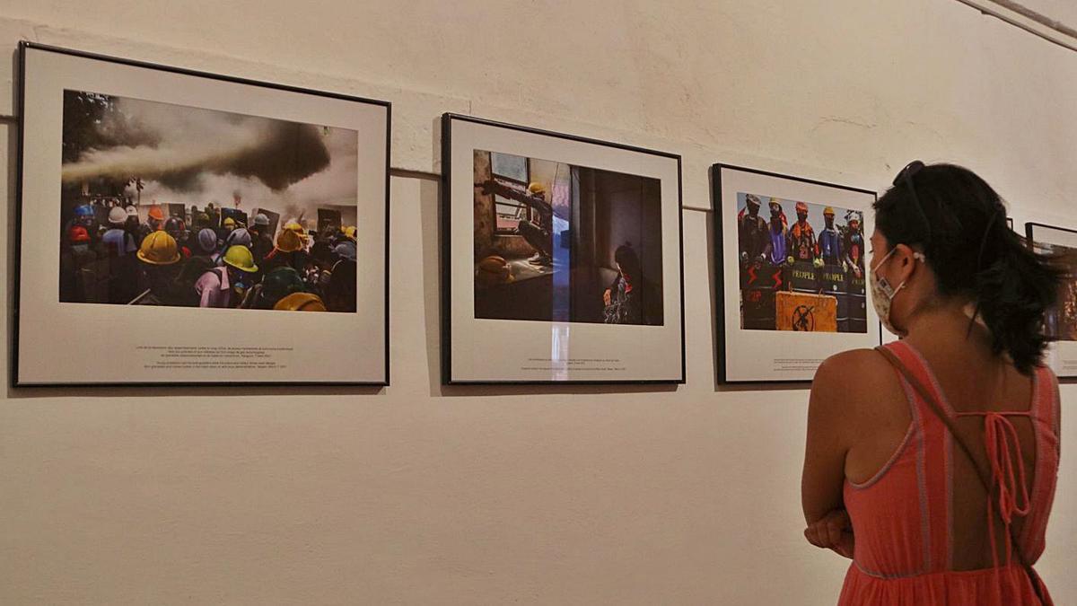 Una noia observant unes fotografies del Visa Pour l’Image a Perpinyà. | GEMMA TUBERT/ACN