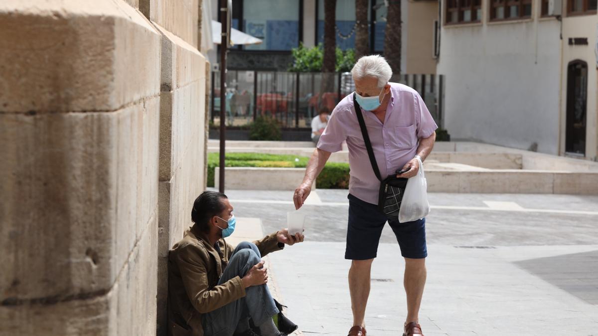 Un hombre pide limosna en una calle de Elche