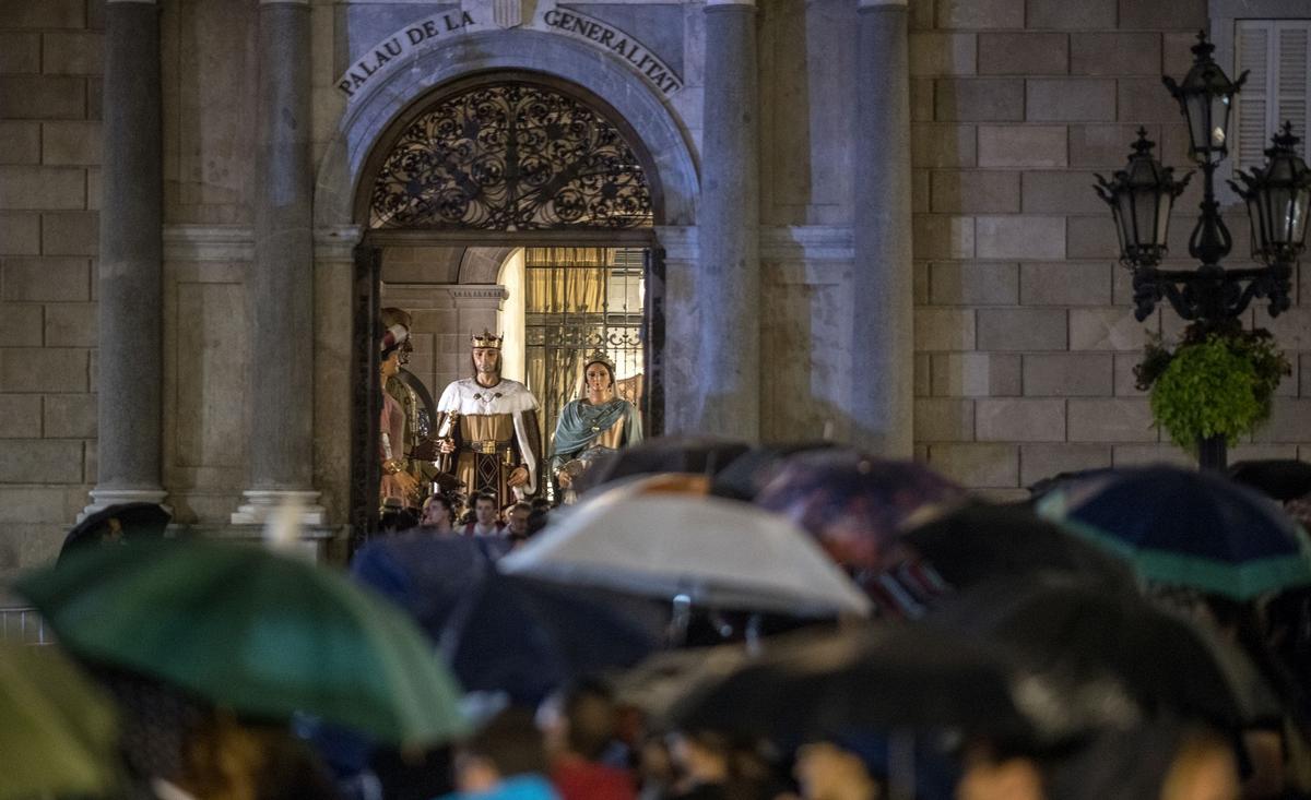 Los ‘gegants’ se protegen de la lluvia en el interior del Palau de la Generalitat durante el inicio de las fiestas de la Mercè en la plaça Sant Jaume.