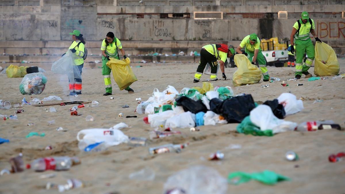 La brigada de limpieza realizando su trabajo en las playas de Barcelona, tras la verbena.