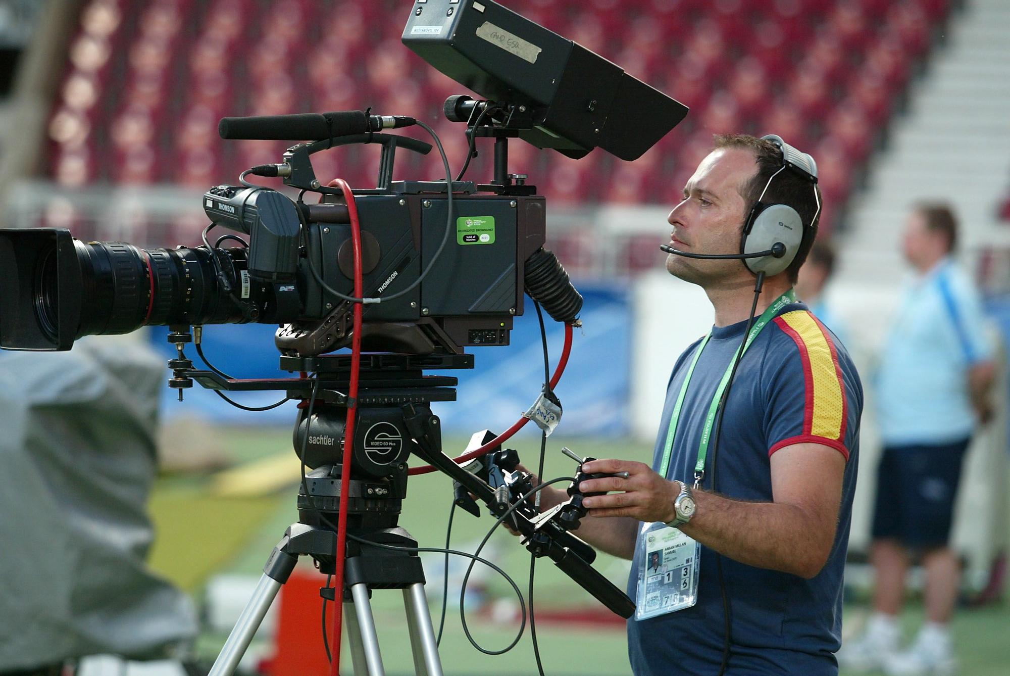 Un operador de cámara trabajando durante un partido de fútbol.