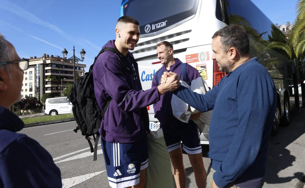 Fernando García, «Ferdi», director general del Alimerka Oviedo, saluda a Daniil Shelist, ayer, antes de salir con destino a La Coruña, con Calvin Hermanson al fondo y a la izquierda un aficionado que fue a despedirlos.