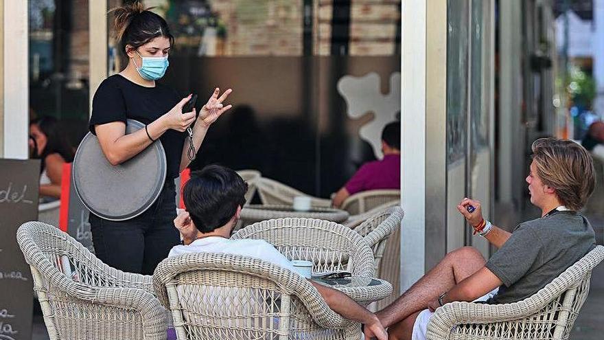 Jóvenes tomando algo en una terraza en Valencia.