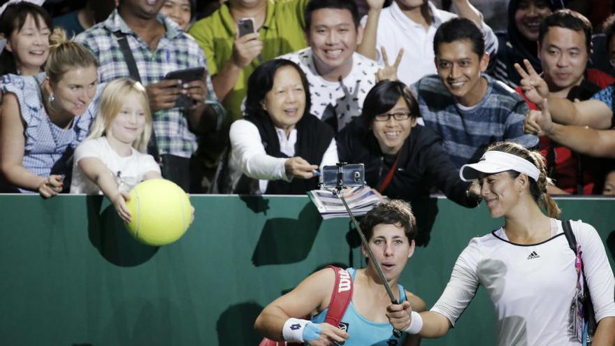 Suárez y Muguruza se hacen un selfie con los aficionados hoy en Singapur