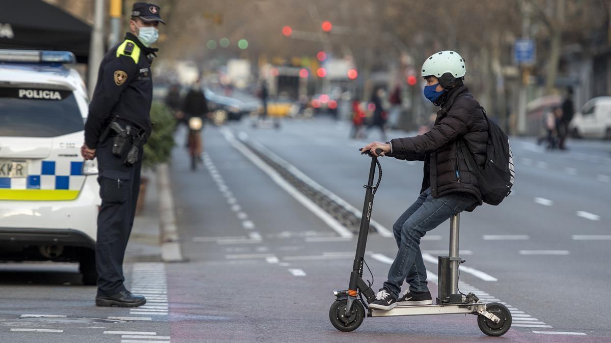 Barcelona 19 01 2021  Barcelona  La Guardia Urbana  en la foto en el cruce de las calles de Diputacion con Urgell  inicio hoy a multar a los usuarios de patinetes que no lleven casco y aquellos que lleven a sus hijos de  paquete   Fotografia de Jordi Cotrina