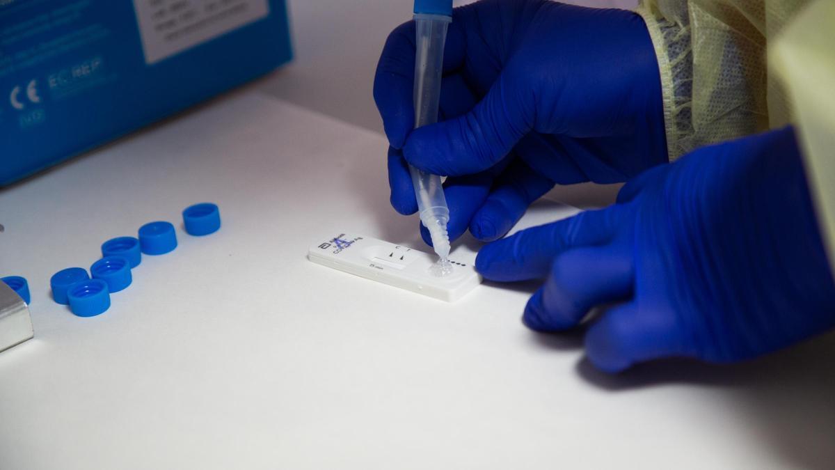 Archivo - Una sanitaria comprueba el resultado de un test de antígenos