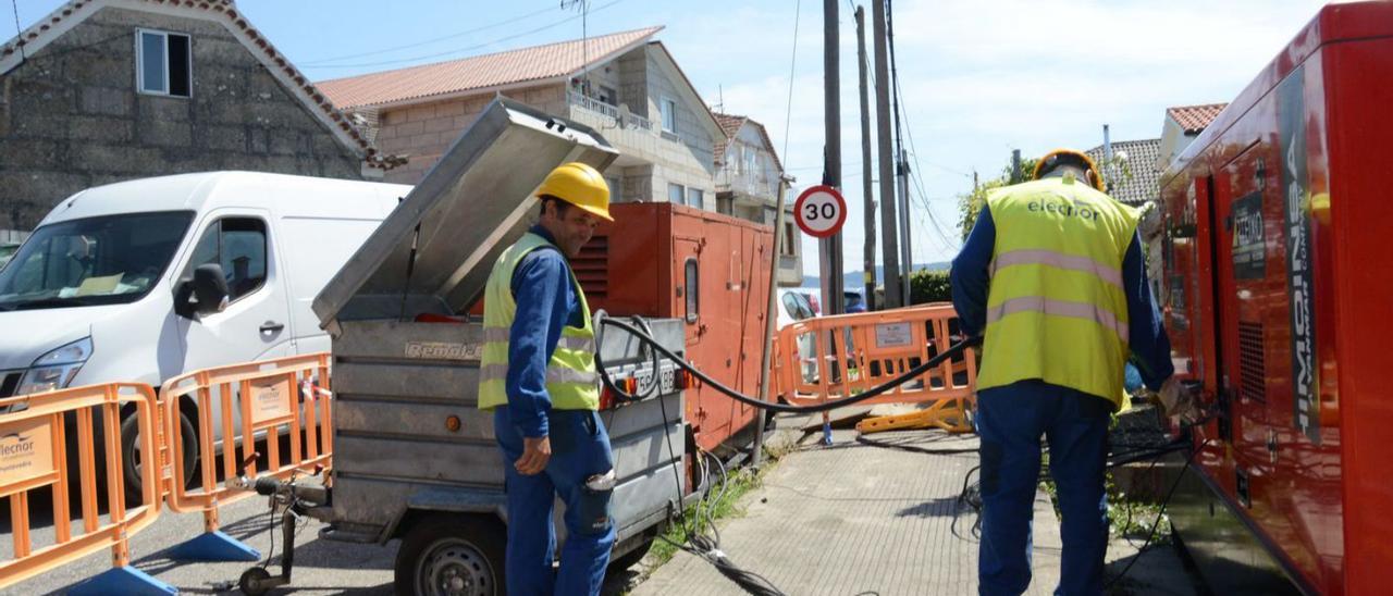 Trabajadores con el grupo electrógeno, ayer, en la zona de Tirán . |   // GONZALO NÚÑEZ