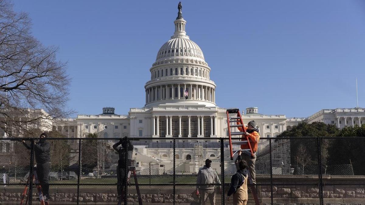 Trabajadores levantan una valla metálica alrededor del Capitolio.