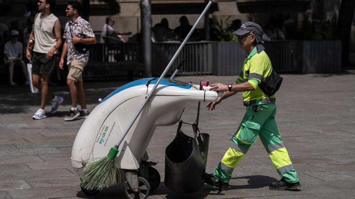 Un operario del servicio de limpieza trabaja bajo el sol en plena ola de calor en Barcelona, el verano pasado.