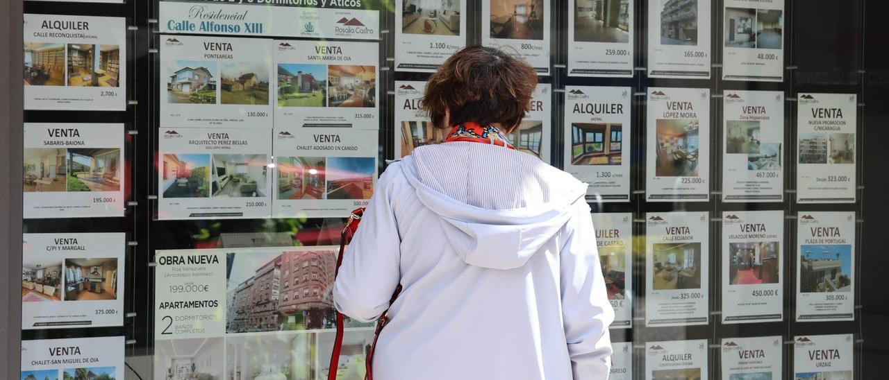 Una mujer observa precios frente a una inmobiliaria.