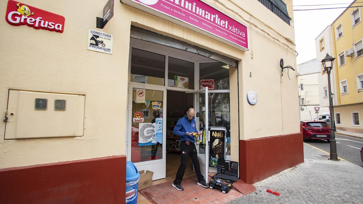 Un operario repara la cerradura de una tienda asaltada en abril de 2022 en Xàtiva.