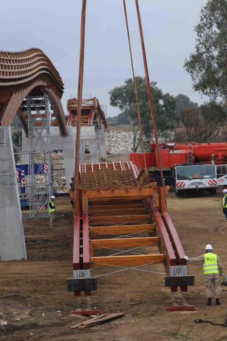 La instalación del último tramo del puente de madera sobre el río Guadalhorce ha comenzado este martes.