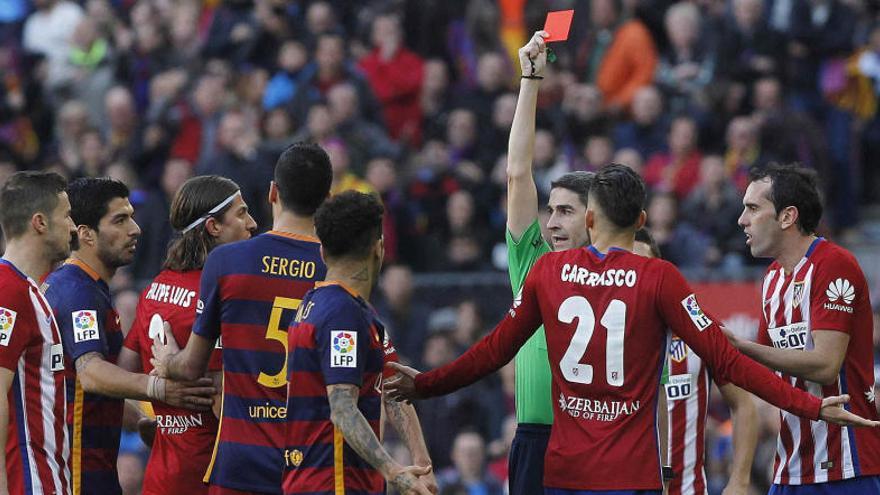 El árbitro muestra la tarjeta roja a Filipe Luis por su entrada a Messi.