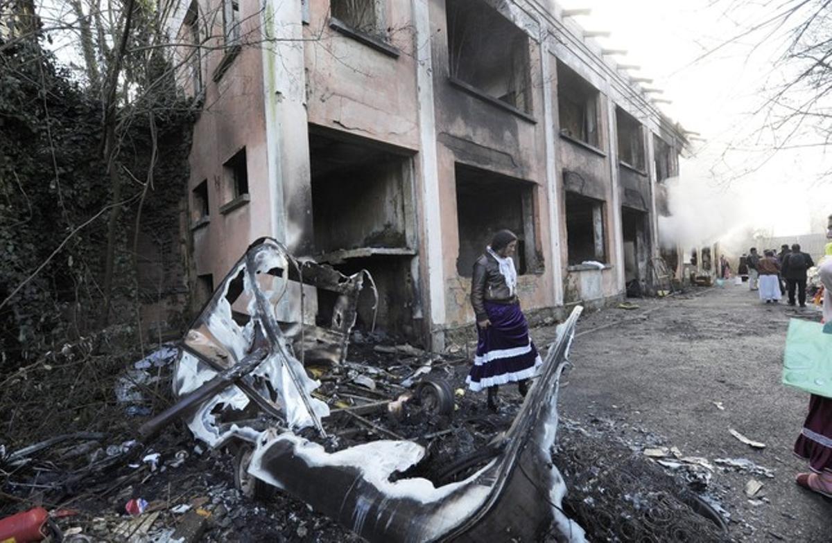 Una mujer, ante los restos de sus pertenencias incendiadas en Turín.