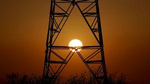 Una torre eléctrica con la puesta de sol