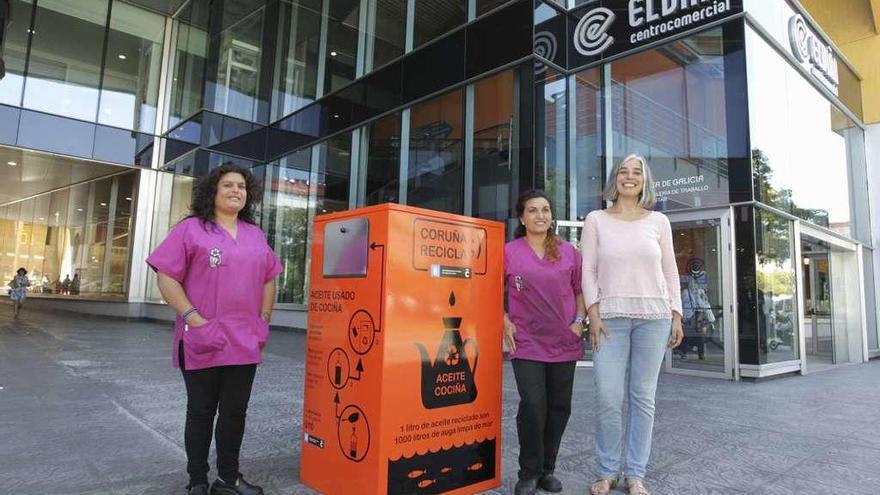 Integrantes de Mulleres Colleiteiras y la edil de Medio Ambiente, con el colector de aceite del Mercado de Elviña.