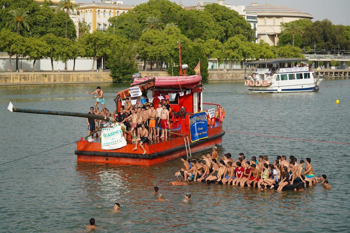 La 'cucaña', el juego centenario que regresa cada verano al río Guadalquivir por la Velá de Santa Ana en imágenes