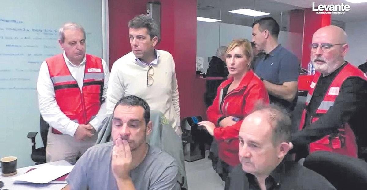 Carlos Mazón, con jersei amarillo, junto a Salomé Pradas, en el Centro de Coordinación de Emergencias, el día de la dana, donde llegó a las 20.28 horas.