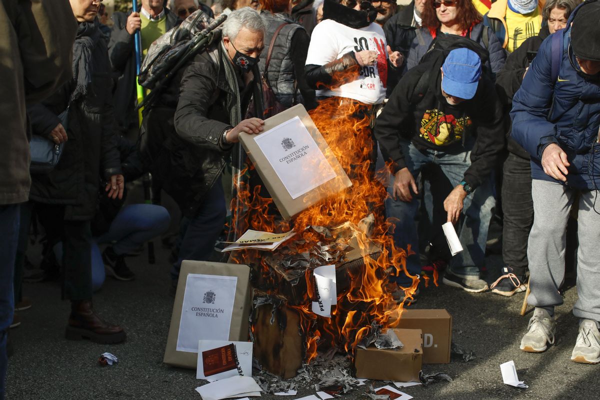 Miembros de los Comités de Defensa de la República (CDR) queman banderas y ejemplares de la Constitución española durante la manifestación de la Asamblea Nacional Catalana en contra de la derogación del delito de sedición en Barcelona este martes.