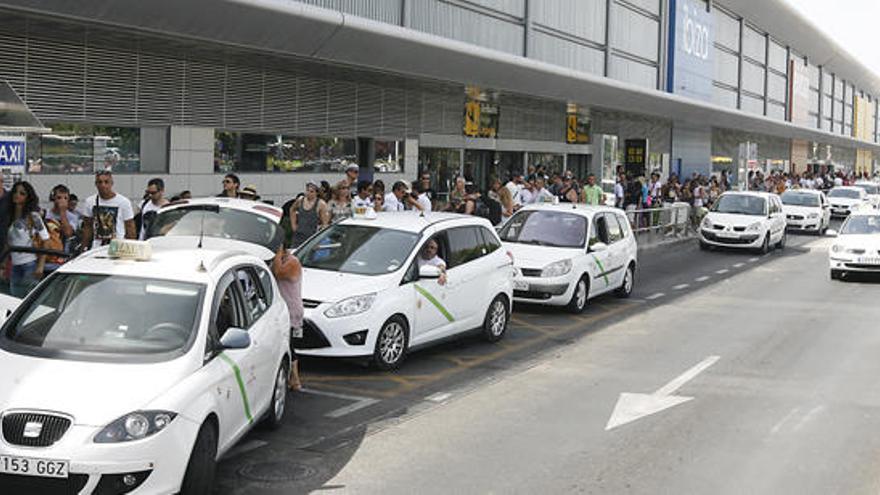 Movimiento de taxis frente a la terminal del aeropuerto en plena temporada turística.