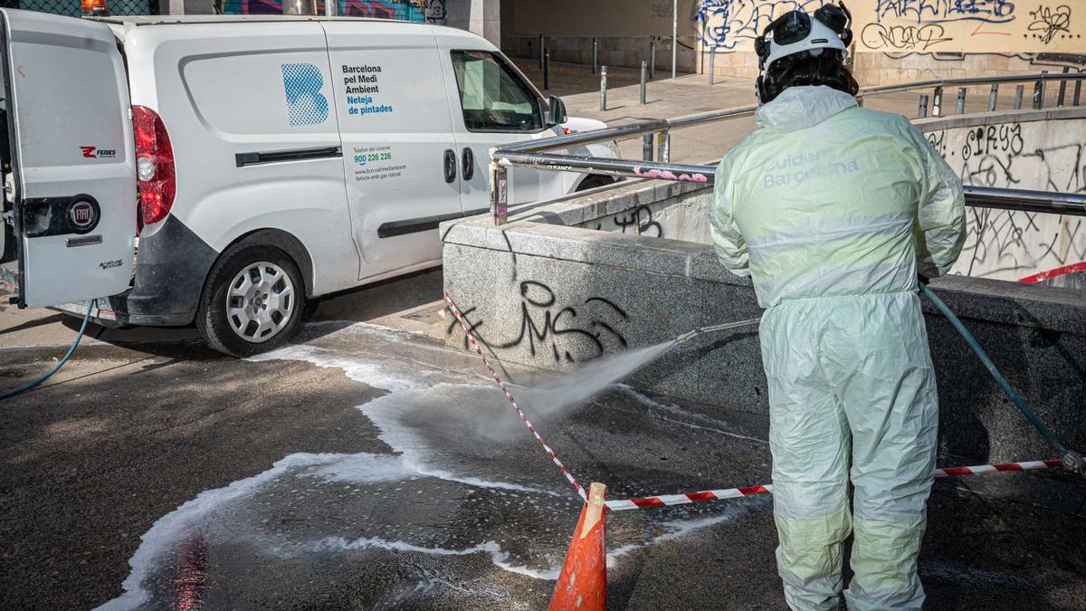 Un operario limpia unas pintadas en la plaza de Castella, en el barrio del Raval de Barcelona.