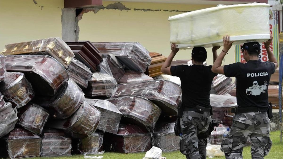 Agentes de policía apilan ataúdes en Pedernales, este lunes.