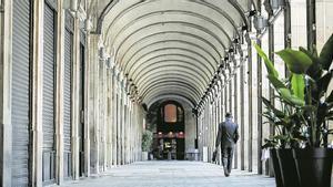 Los porchos de la plaza Reial (Barcelona) vacía de turistas con los restaurantes cerrados. 