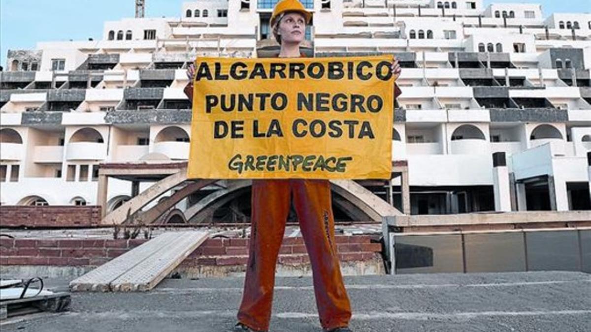 Una activista de Greenpeace protesta frente a la mole de cemento de El Algarrobico, el pasado mayo.