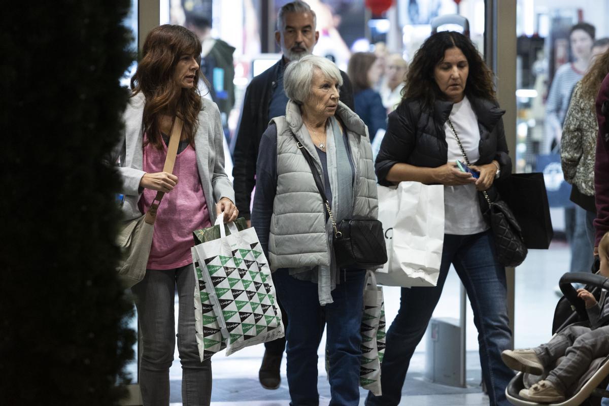 Mujeres cargan varias bolsas tras sus compras en el centro de València.