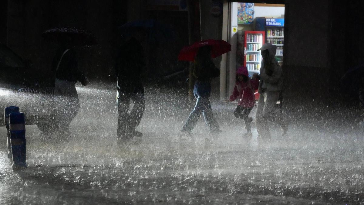 Transeúntes se protegen de la lluvia intensa caída en Barcelona este jueves.