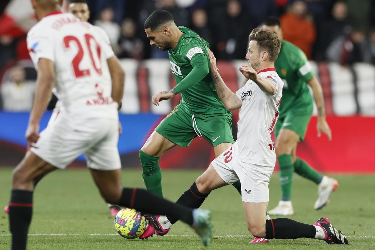 Sevilla, 28/01/2023.- El centrocampista croata del Sevilla Ivan Rakitic (d) lucha con Omar Mascarell, del Elche, durante el encuentro correspondiente a la jornada 19 que Sevilla FC y Elche CF disputan hoy sábado en el estadio Sánchez-Pizjuán, en Sevilla. EFE/José Manuel Vidal.