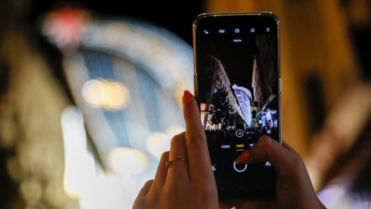 Una mujer fotografía el alumbrado de Navidad de Córdoba.