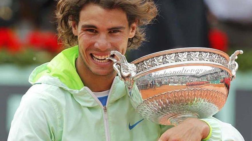 Nadal, fiel a su costumbre, muerde el trofeo mientras posa para los fotógrafos.