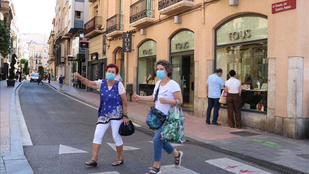 Peatones con mascarilla, en una calle de Reus.