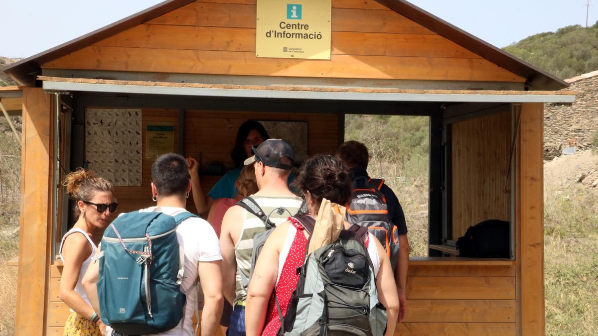 Un grup de turistes al punt d'informació a l'inici de les restriccions del Parc Natural de Cap de Creus a Cadaqués. | GEMMA TUBERT